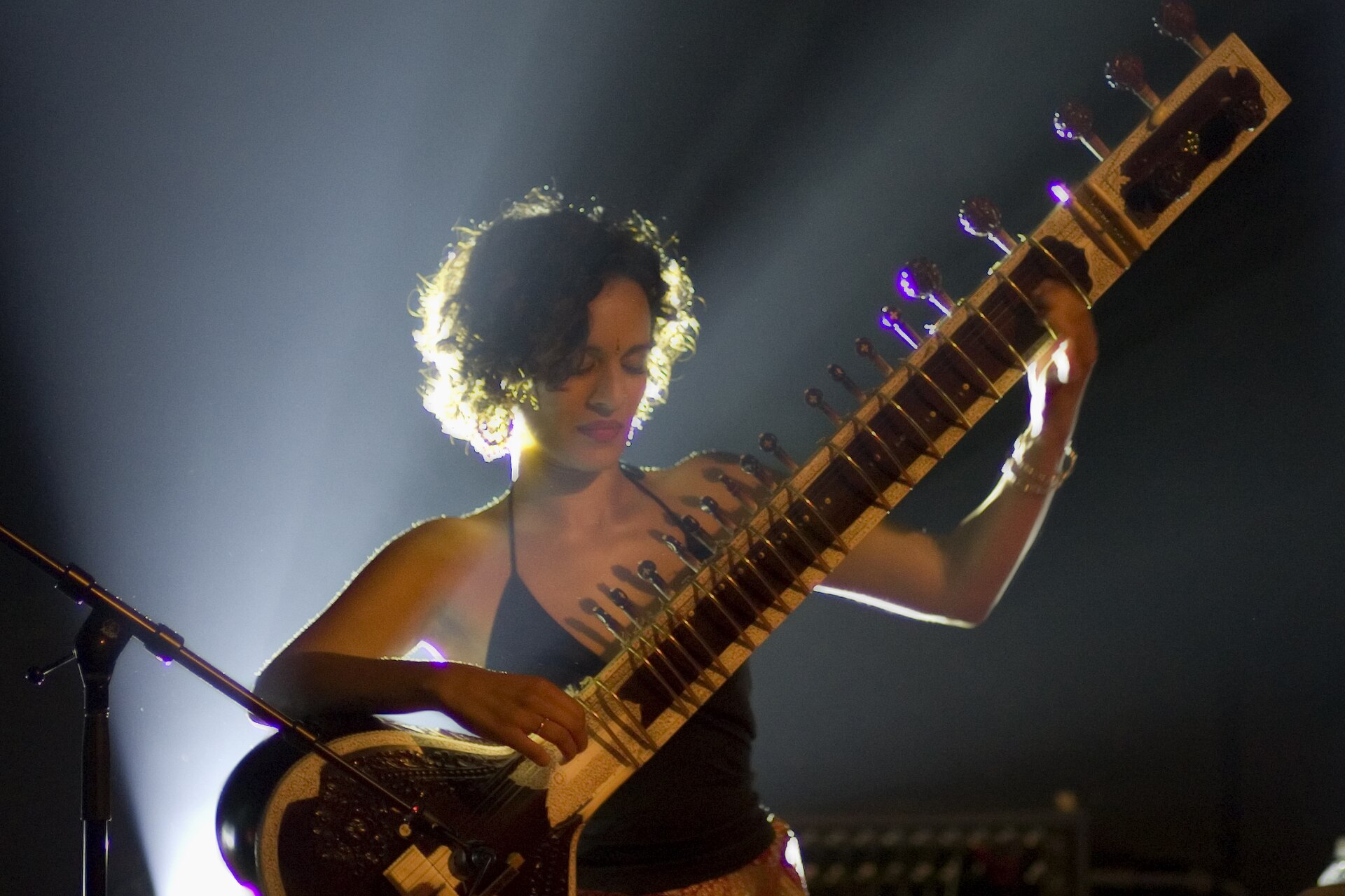 Anoushka Shankar playing sitar under stage lights