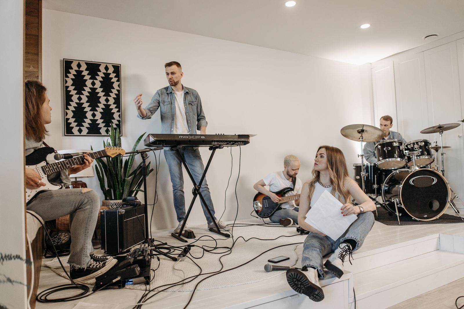Young musicians rehearsing together with drums, guitars and a keyboard