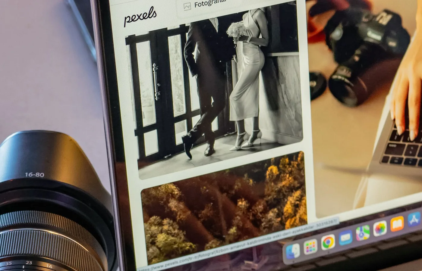 A photographer working on an image edit on a laptop beside a camera