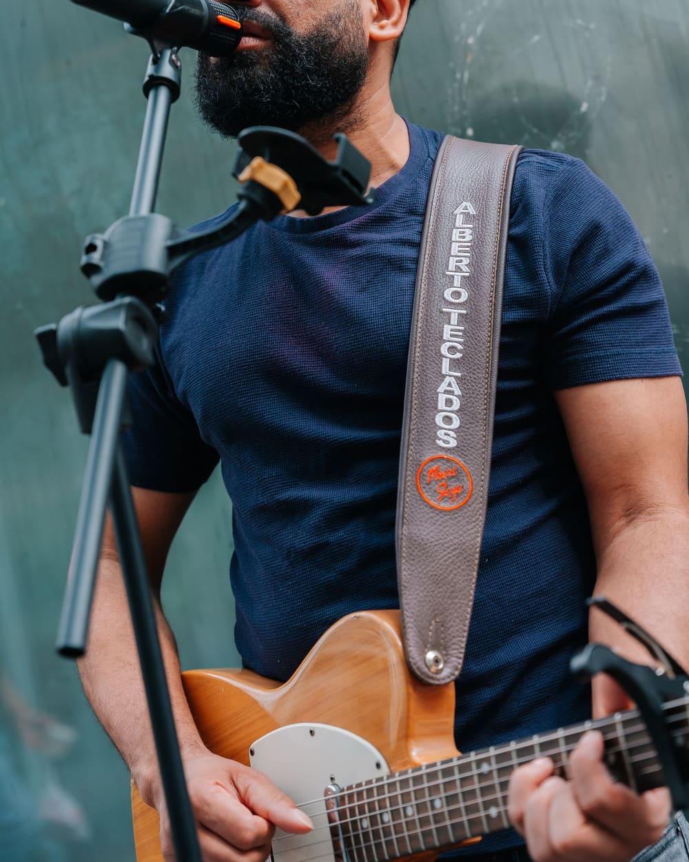 A street musician performing outdoors with a guitar and microphone